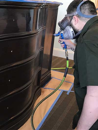 Craftsman working on hotel furniture refinishing